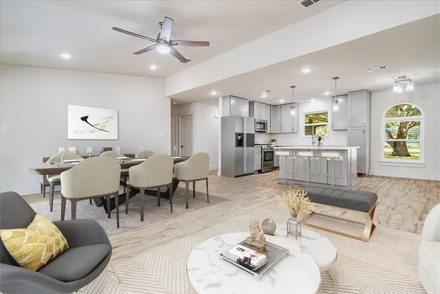 a living room with stainless steel appliances kitchen island granite countertop furniture and a dining table