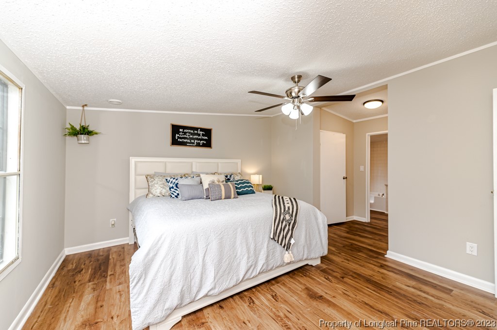 243 Hollywood Road Cameron, NC 28326 - Photo 12 of 39 a bedroom with a bed and a ceiling fan