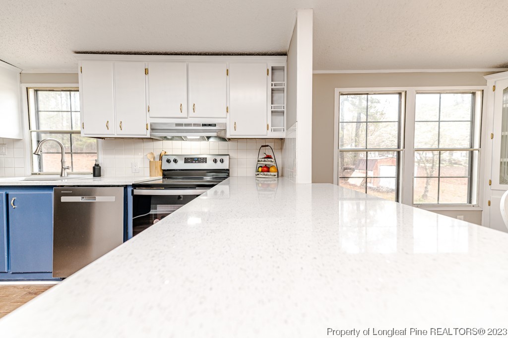 243 Hollywood Road Cameron, NC 28326 - Photo 23 of 39 a kitchen with stainless steel appliances kitchen island granite countertop a refrigerator a sink dishwasher and white cabinets with wooden floor