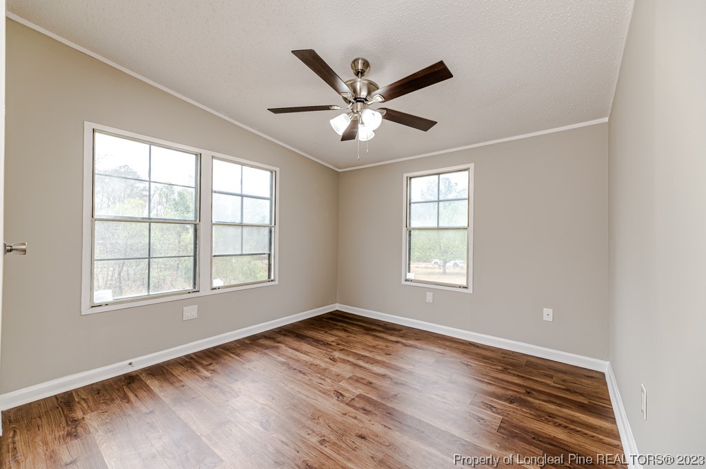 243 Hollywood Road Cameron, NC 28326 - Photo 32 of 39 a view of an empty room with wooden floor and a window