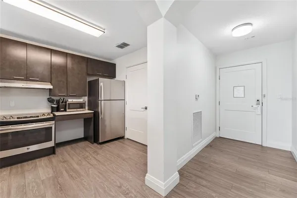 a kitchen with a refrigerator and a stove top oven