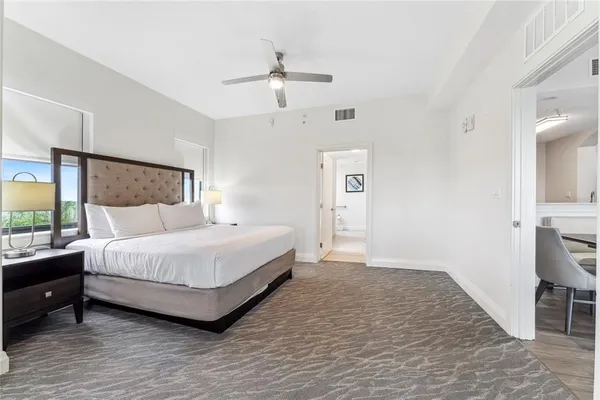 a spacious bedroom with a bed and a dresser