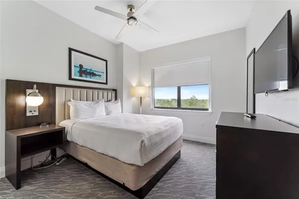 a bedroom with a large bed and a flat tv screen on a dresser