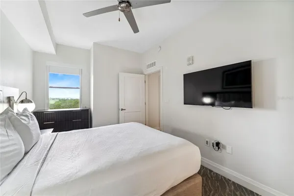 a bedroom with a large bed and a flat screen tv