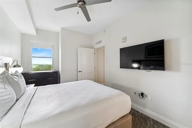 a bedroom with a large bed and a flat screen tv