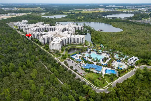 an aerial view of a residential houses with outdoor space and ocean view