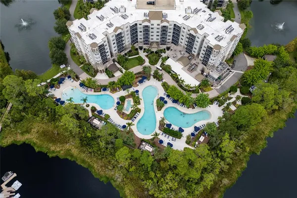 an aerial view of multi story residential apartment building with yard and parking space