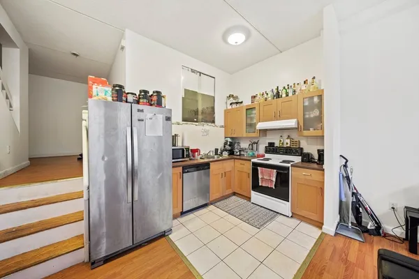 a kitchen with granite countertop stainless steel appliances a refrigerator and a stove top oven