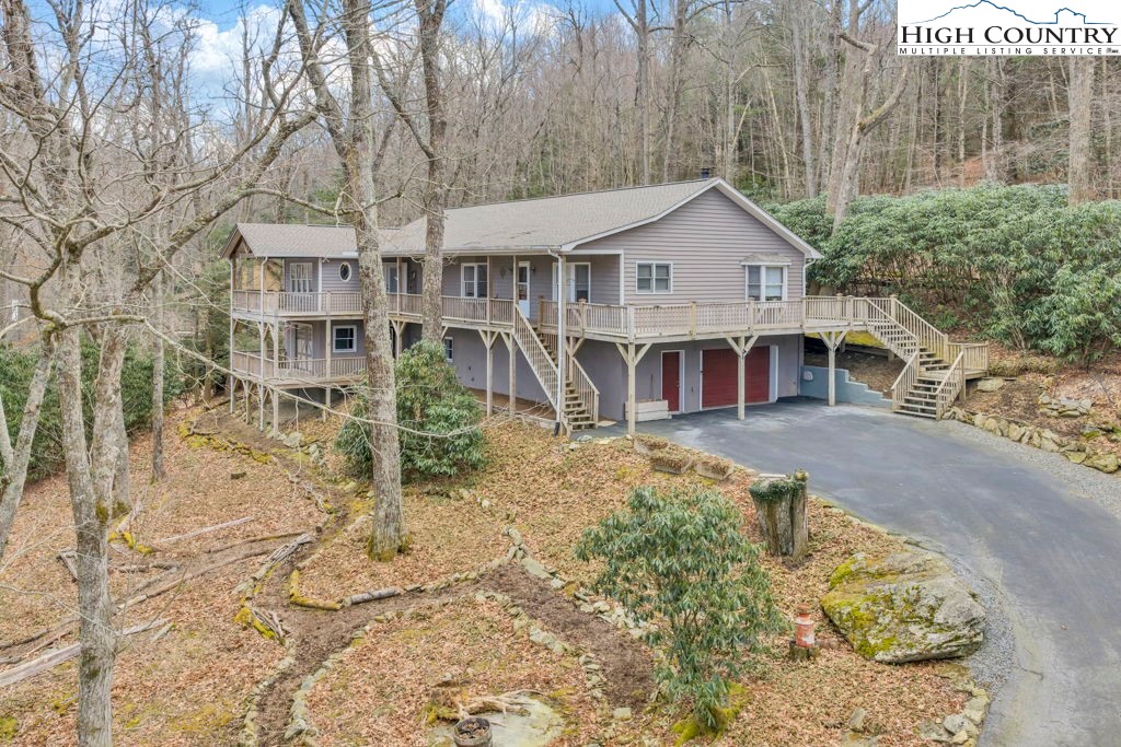 472 Virgil's Lane Boone, NC 28607 - Photo 2 of 44 a view of a white house with large trees and wooden fence