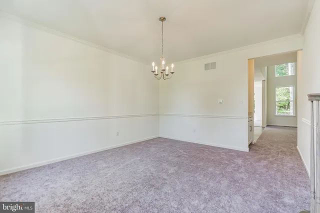 an empty room with chandelier fan