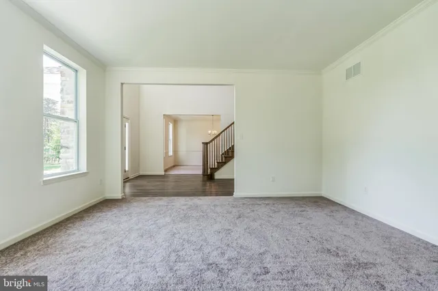 an empty room with windows and cabinet