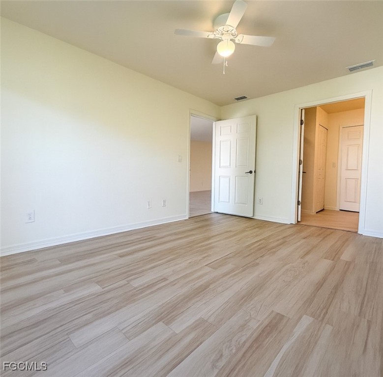 3304 Skyline Boulevard, Unit 202 Cape Coral, FL 33914 - Photo 12 of 20 a view of empty room with wooden floor and fan
