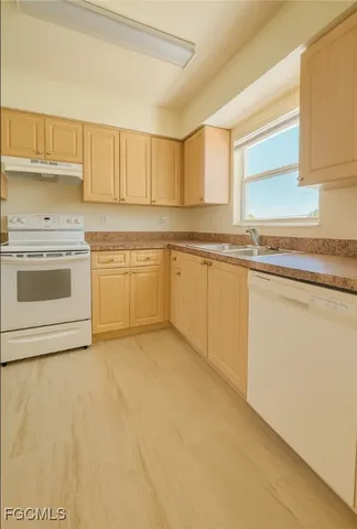 a view of a hallway with wooden floor and a kitchen