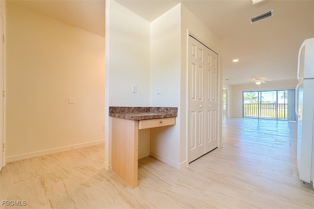 3304 Skyline Boulevard, Unit 202 Cape Coral, FL 33914 - Photo 4 of 20 a view of a hallway with wooden floor and a kitchen