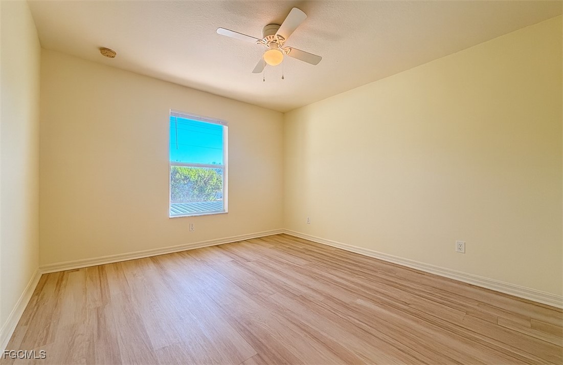 3304 Skyline Boulevard, Unit 202 Cape Coral, FL 33914 - Photo 7 of 20 an empty room with wooden floor and windows