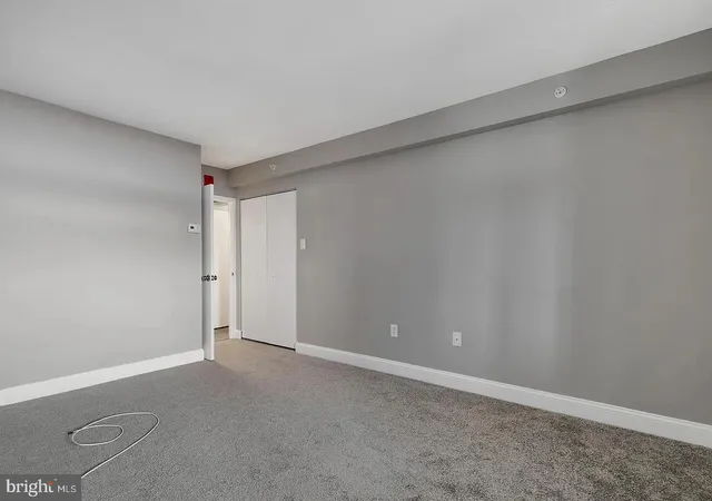 a view of an empty room with wooden floor and windows