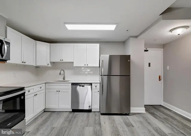 a kitchen with a refrigerator a sink and cabinets