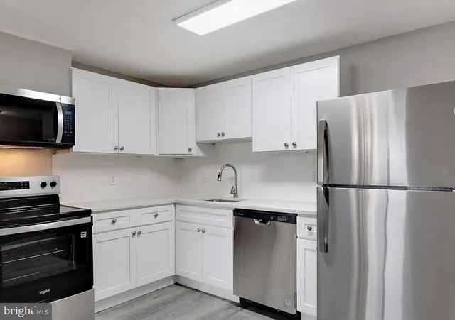 a kitchen with stainless steel appliances a refrigerator sink and cabinets