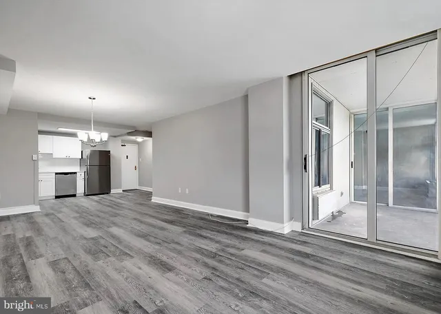 a view of a big room with wooden floor and a kitchen