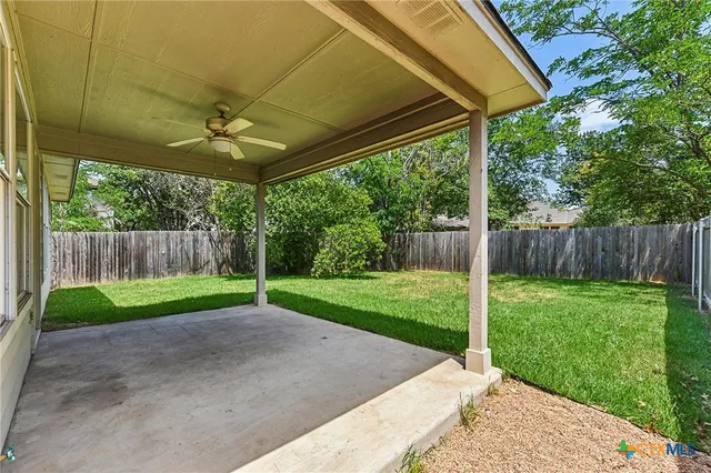 a view of a backyard with wooden fence