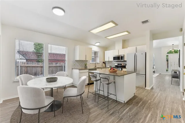 a kitchen with stainless steel appliances kitchen island granite countertop a sink and refrigerator