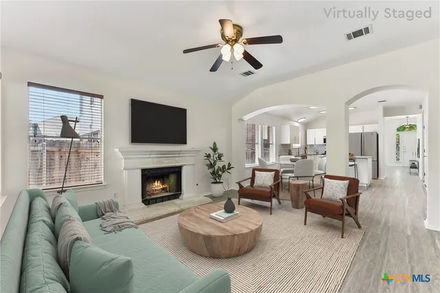 a living room with furniture a fireplace and a flat screen tv