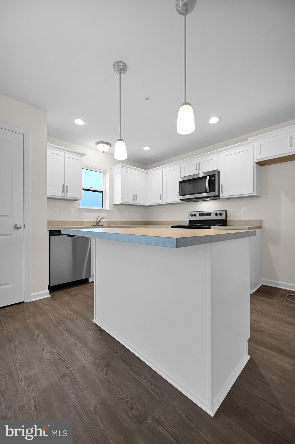 20 Landing Place, Unit 20 York, PA 17408 - Photo 11 of 27 a kitchen with stainless steel appliances granite countertop a sink a stove a refrigerator and island with wooden floor