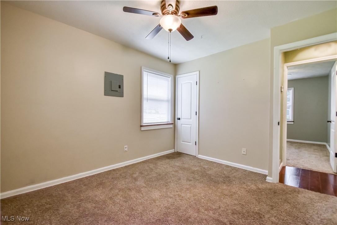 1919 Sandgate Road Madison, OH 44057 - Photo 16 of 28 Unfurnished bedroom with dark carpet, electric panel, ceiling fan, and a closet