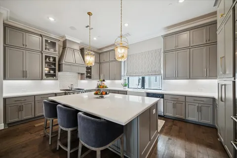 a kitchen with stainless steel appliances granite countertop a sink a stove a refrigerator and island