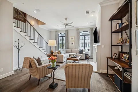 a living room with furniture stairs and a chandelier