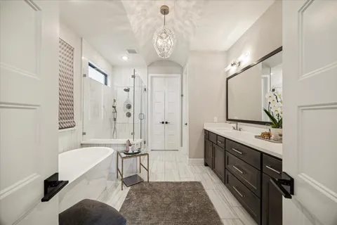 a spacious bathroom with a double vanity sink a mirror a bathtub and shower