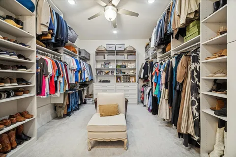a view of walk in closet with clothes and shoes