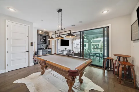 a room with furniture pool table flat screen tv and a large window