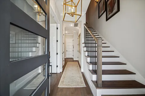a view of staircase with lots of frames on wall and a window