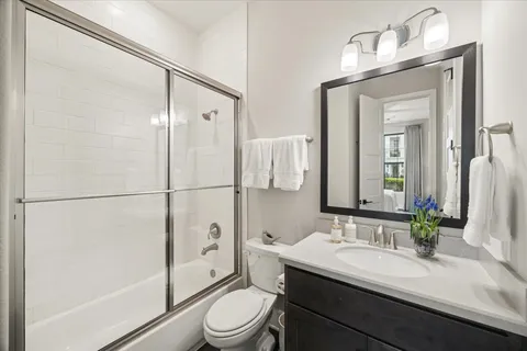 a bathroom with a sink a toilet and a large mirror