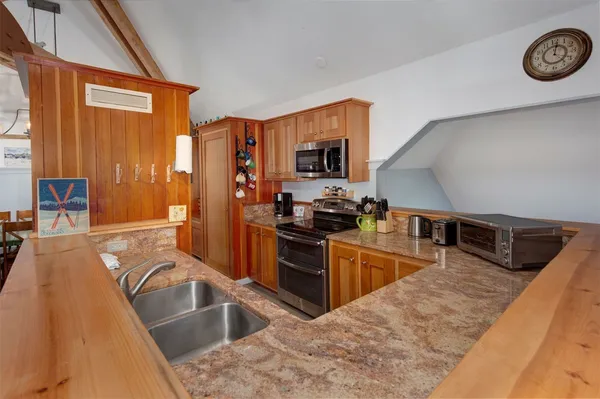 a kitchen with stainless steel appliances granite countertop a sink dishwasher stove and refrigerator with wooden floor