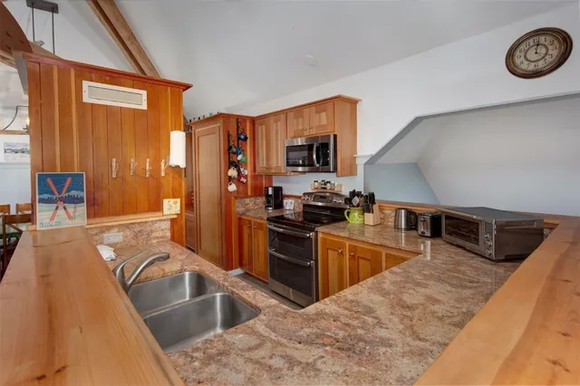 a kitchen with stainless steel appliances granite countertop a stove a sink and a microwave