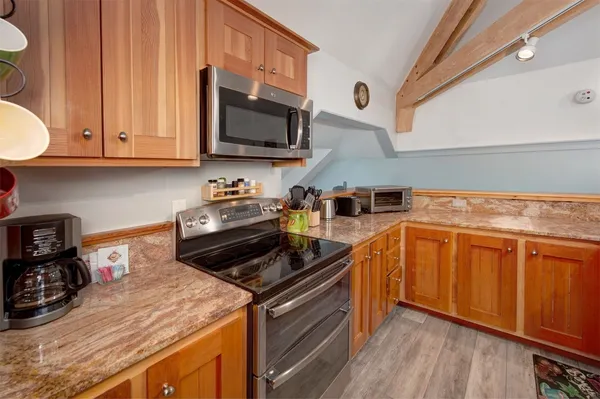 a kitchen with stainless steel appliances granite countertop a stove a sink and a microwave