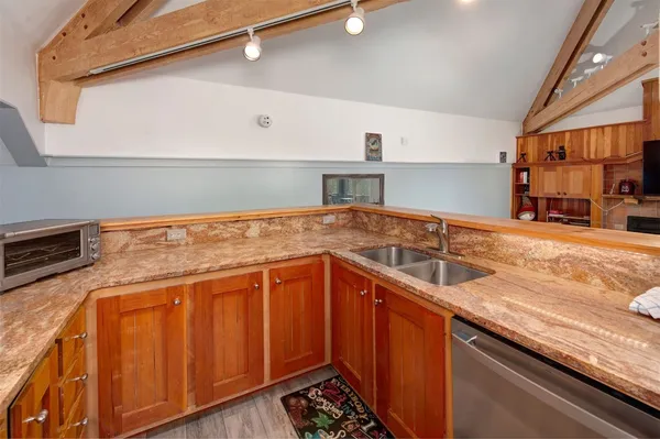 a kitchen with granite countertop a sink and cabinets
