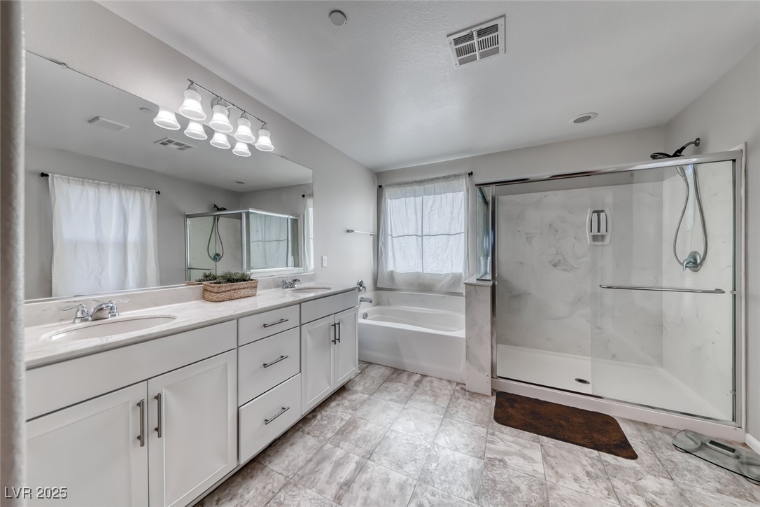 723 Gorringe Ridge Court Henderson, NV 89002 - Photo 25 of 48 Bathroom featuring double vanity, a marble finish shower, and a garden tub