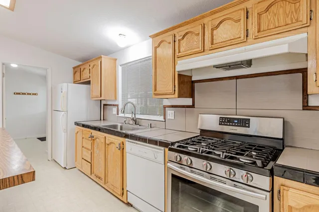 a kitchen with stainless steel appliances granite countertop a stove and a sink