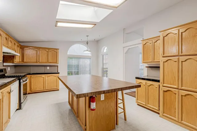 a kitchen with stainless steel appliances granite countertop a sink a stove and a refrigerator