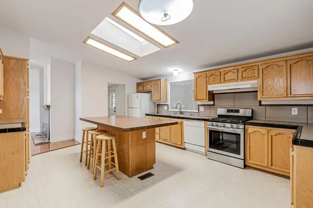 a kitchen with stainless steel appliances granite countertop a stove a sink dishwasher and a refrigerator