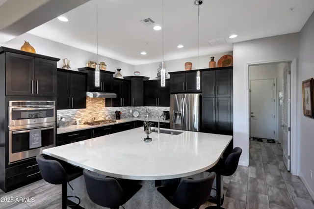a kitchen with stainless steel appliances granite countertop a sink and a refrigerator