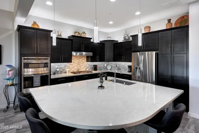 a kitchen with stainless steel appliances granite countertop a sink stove and refrigerator