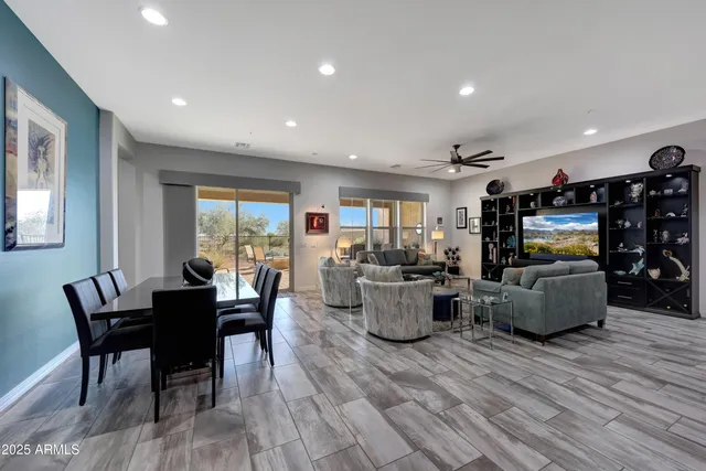 a living room with furniture ceiling fan and a large window