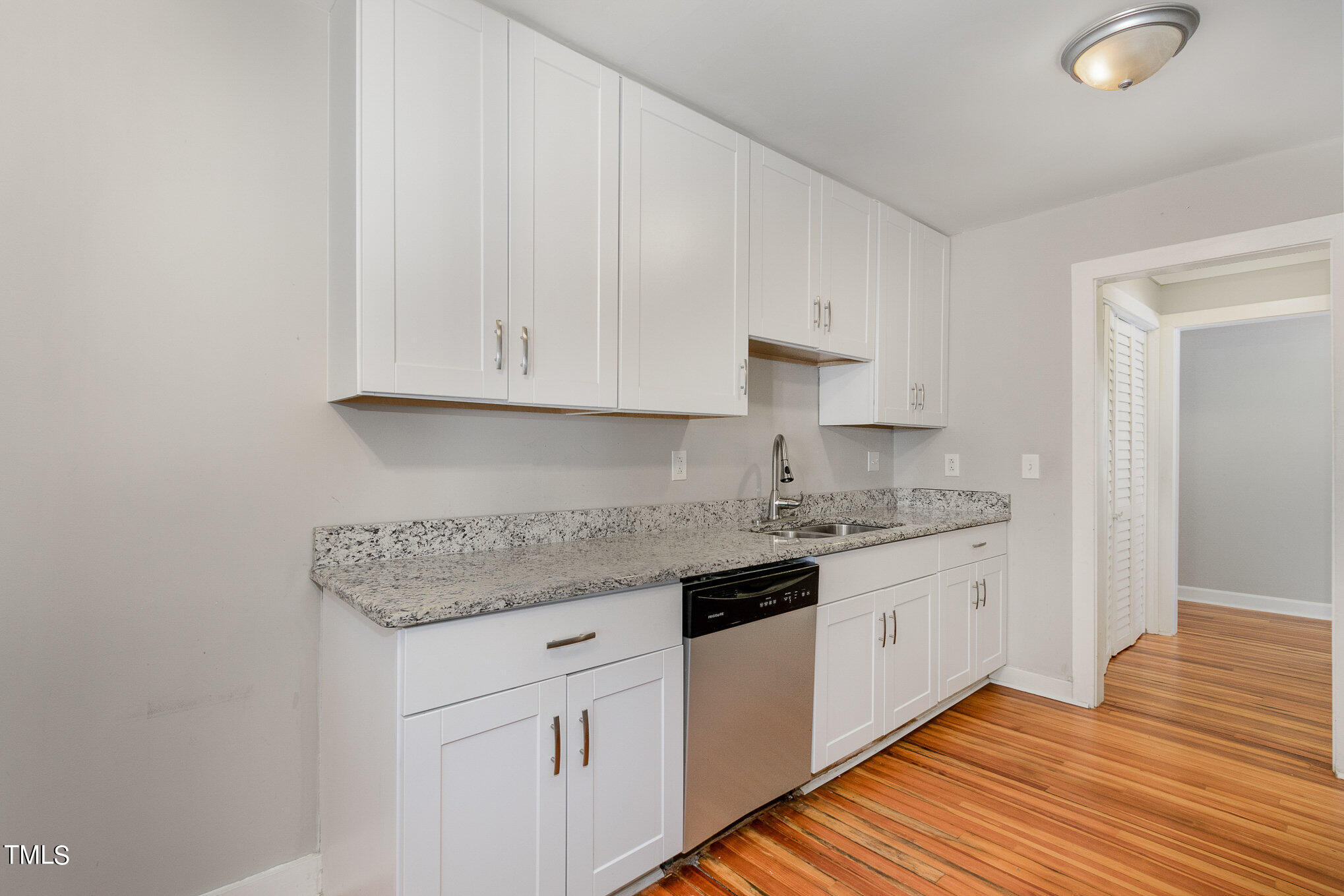 6309 Garrett Road Durham, NC 27707 - Photo 5 of 17 a kitchen with stainless steel appliances granite countertop a stove a sink and white cabinets
