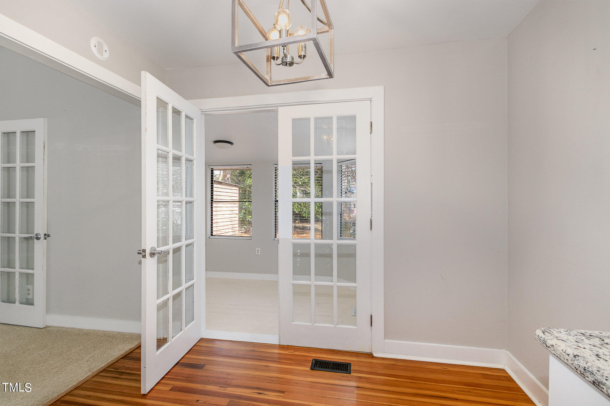 6309 Garrett Road Durham, NC 27707 - Photo 6 of 17 a view of an empty room with wooden floor and a window