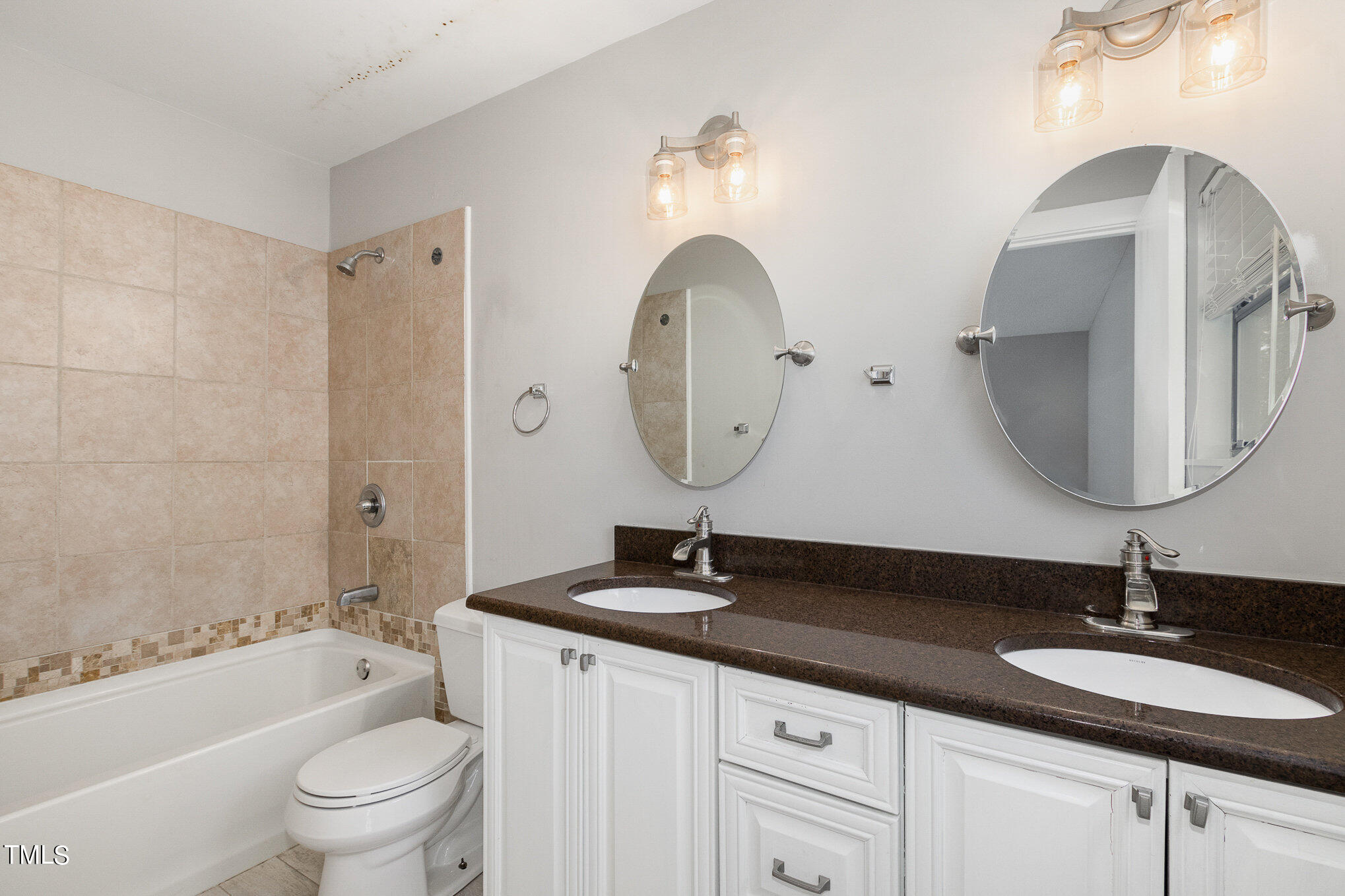 6309 Garrett Road Durham, NC 27707 - Photo 9 of 17 a bathroom with a double vanity sink and a mirror