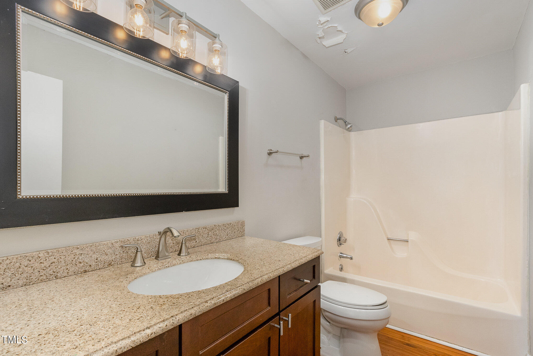 6309 Garrett Road Durham, NC 27707 - Photo 10 of 17 a bathroom with a granite countertop sink toilet mirror and shower